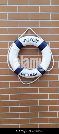 Blue and white colored lifebelt hanging on the brick wall of the sailing clubhouse Stock Photo