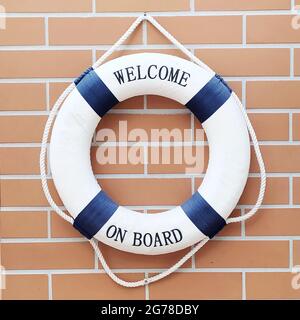 Blue and white colored lifebelt hanging on the brick wall of the sailing clubhouse Stock Photo