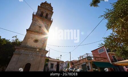 Ionian Islands, Zakynthos, village Kiliomenos, church tower, wide-angle view from diagonally below right, slight distortion, sunbeams behind the church tower, back light, blue sky Stock Photo