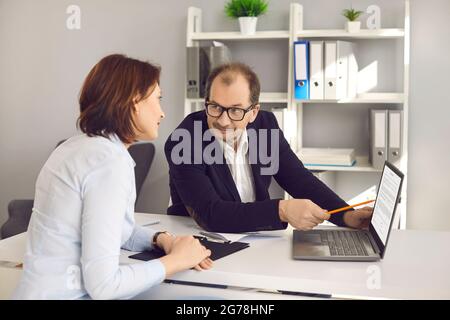 Businessman present project on laptop screen explain business idea to partner Stock Photo
