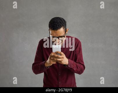 Black man holding mobile phone and laughing at funny memes and jokes on the Internet Stock Photo