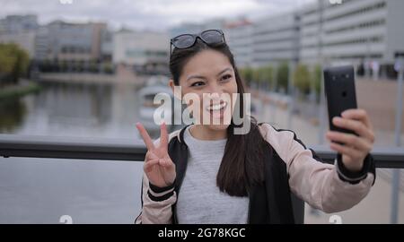 Young Asian woman takes a selfie in an urban area - people photography Stock Photo