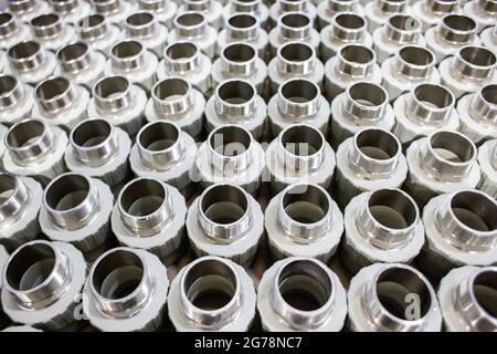 many metal pipe couplings in a pipe factory Stock Photo