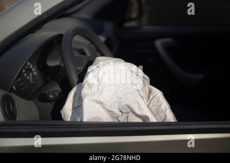 The airbag has deployed. Car after an accident. The driver's seat is distorted. Safety device in the car. Stock Photo