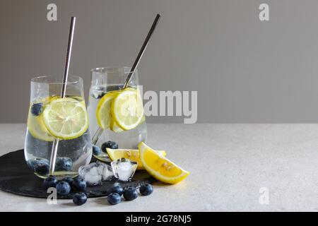 Cold drinks in small bottles. Cherries and lemon lemonade or cocktail. Stock Photo