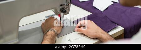 partial view of tailor using sewing machine in fashion atelie, banner Stock Photo