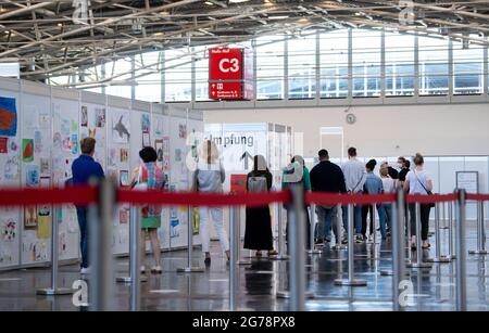 Munich, Germany. 12th July, 2021. People wait to be vaccinated at the vaccination center at Messe München. Since 12.07.2021, students of graduating classes can also be vaccinated. Credit: Sven Hoppe/dpa/Alamy Live News Stock Photo