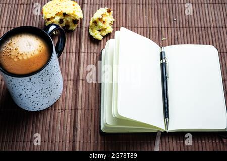 Blank notebook with mechanical pencil, muffin and coffee mug. Stock Photo
