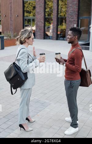 Two successful multiracial colleagues talking against building exterior Stock Photo