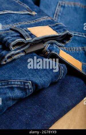 Stack of variety blue jeans, denim jean textiles as background. different blue jeans trousers stack textile texture fabric background Stock Photo