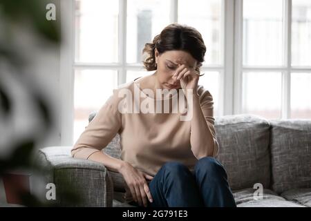 Unhappy mature woman feel distressed alone at home Stock Photo