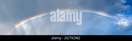 Beautiful sky with bright rainbow and fluffy clouds Stock Photo - Alamy