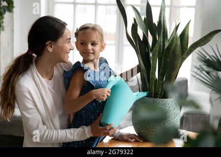 Smiling mother and small daughter water plant Stock Photo