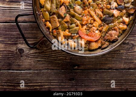 Traditional paella on a wooden table. Spanish food, food to share with the family Stock Photo