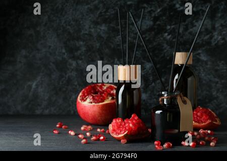 Aroma scent diffusers and pomegranate on dark wooden table Stock Photo