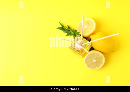 Diffuser, lemons and leaves on yellow background Stock Photo