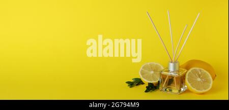 Diffuser, lemons and leaves on yellow background Stock Photo