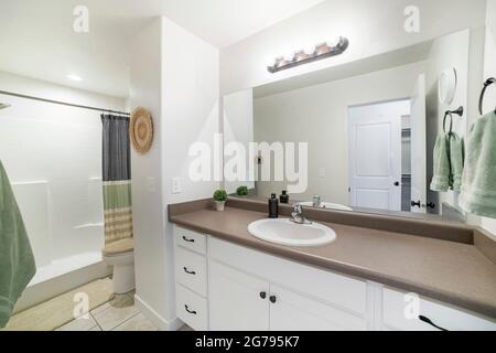 Interior of a bathroom with white marble top sink with white cabinet and mirror Stock Photo