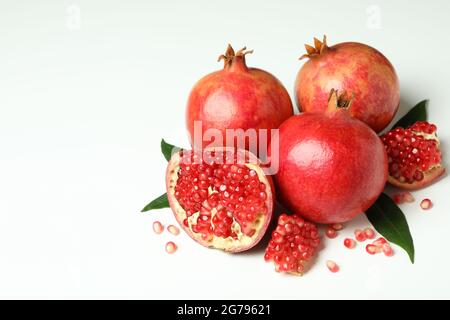 Ripe pomegranate with leaves on white background Stock Photo