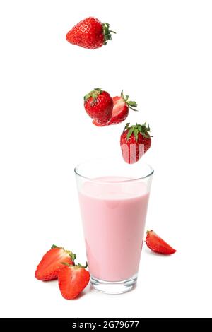 Glass of strawberry milkshake and falling strawberries isolated on white background Stock Photo