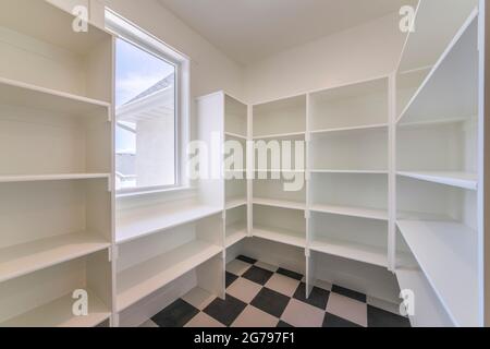Interior of an empty kitchen pantry in a house with window Stock Photo