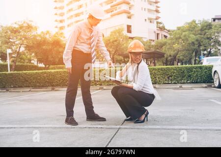 engineer slater associates for workers security on background of new highrise apartment buildings.Complain Construction workers working on a job toget Stock Photo