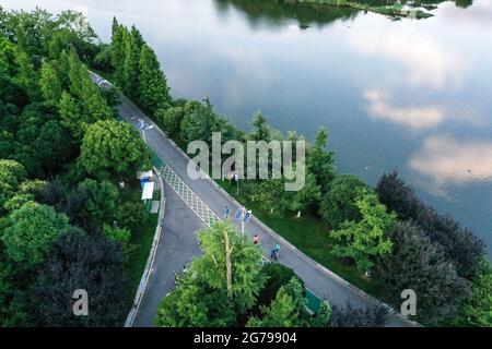 Guiyang. 7th July, 2021. Aerial photo taken on July 7, 2021 shows citizens walking at Guanshanhu Park in Guiyang City, southwest China's Guizhou Province. Credit: Yang Wenbin/Xinhua/Alamy Live News Stock Photo