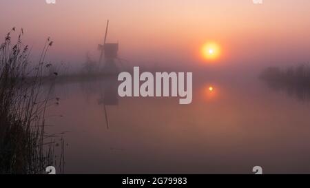 Impressions of a spring hike at sunrise and fog in South Holland in the Alblasserwaard Vijfheerenlanden region near Kinderdijk: windmill at sunrise and fog. Stock Photo