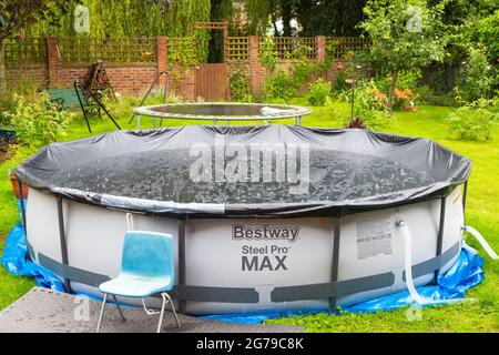 Ashford, Kent, UK. 12th Jul, 2021. UK Weather: A children's paddling pool is seen covered over as heavy rain hits Ashford in Kent. Photo Credit: Paul Lawrenson /Alamy Live News Stock Photo
