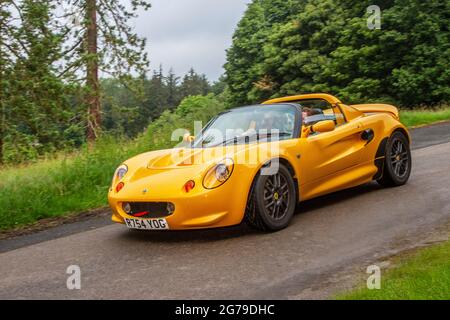 1998 90s yellow Lotus Elise 5 speed manual 1796cc petrol sports car en-route KLMC The Cars the Star Show in Holker Hall & Gardens, Grange-over-Sands, UK Stock Photo