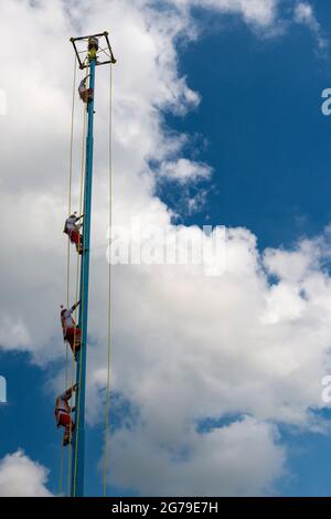 Papantla, Mexico - May 21, 2014: A group of voladores (flyers) climbing the pole to perform the traditional Danza de los Voladores (Dance of the Flyer Stock Photo