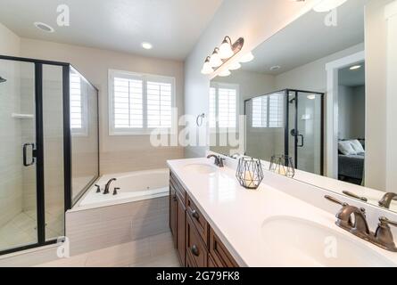 Interior of a master bathroom with double vanity sink and windows Stock Photo