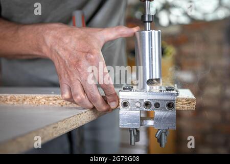 The carpenter works as a professional tool for drilling wood. Stock Photo