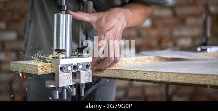 The carpenter works as a professional tool for drilling wood. Stock Photo