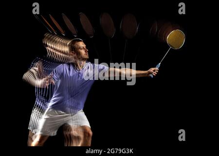 Young male badminton player, shuttler in motion and action on dark ...