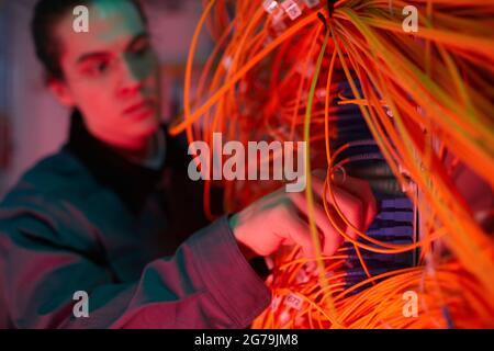 Close up of network technician arranging cables and wires in server room, copy space Stock Photo