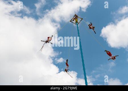 Papantla, Mexico - May 21, 2014: A group of voladores (flyers) climbing the pole to perform the traditional Danza de los Voladores (Dance of the Flyer Stock Photo