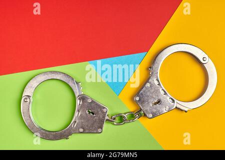 Handcuffs on popular browser logo from paper. Cyber criminal caught concept. Red, yellow, green and blue colors. Colorful and bright logo Stock Photo