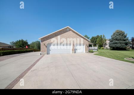 Double garage doors adjacent to each other with wall bricks and wall lamp Stock Photo
