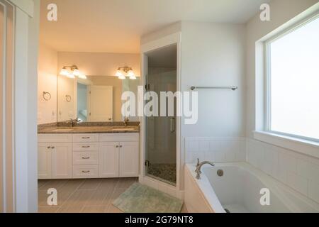 Master bathroom with corner shower stall and window Stock Photo