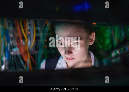 Close up of female network engineer inspecting servers while working with supercomputer in data center, copy space Stock Photo