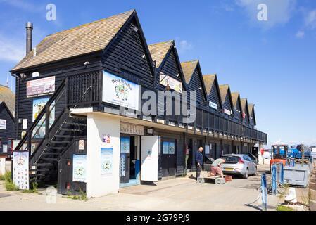 Sea food shops in Black painted fishermans huts and oyster sheds in Whitstable Harbour Whitstable Kent England UK GB Europe Stock Photo