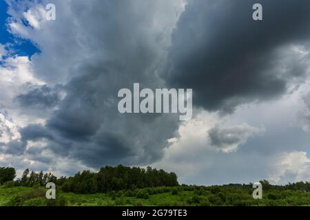 Extreme thunderstorm clouds moving over fields, climate change concept Stock Photo