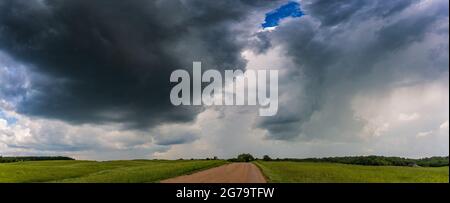 Extreme thunderstorm clouds moving over fields, climate change concept Stock Photo