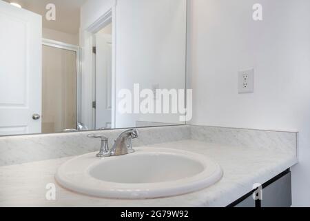 Single vanity sink with white marble countertop on a white bathroom Stock Photo