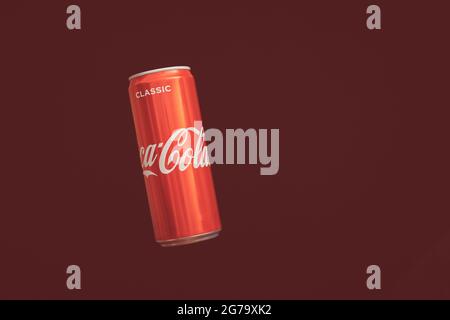 KALININGRAD, RUSSIA - MARCH 13, 2021 - Coca Cola can, red background. Classic coke jar, carbonated soft drink. Manufactured by The Coca-Cola Company. Stock Photo