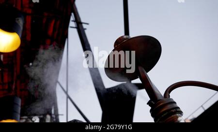 Hookah shisha smoke on city background. Close-up of a hookah bowl with charcoal. Hookah bar outside. Stock Photo