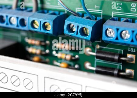 Terminal blocks for the transmission of IO signals. Close up. Selective focus one block with defocused hard drive.  Also known as electrical blocks. Stock Photo