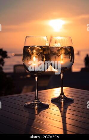 two glasses and sunset in the beach Stock Photo