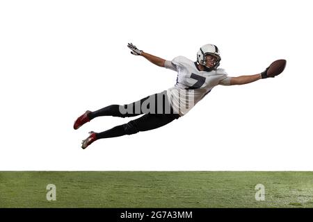 Portrait of American football player catching ball in jump isolated on white studio background. Stock Photo